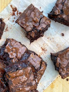 chocolate brownies sitting on top of a piece of parchment paper