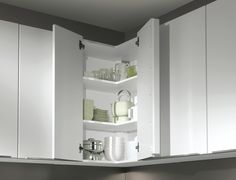 an open cabinet with dishes and cups in it