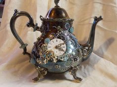 an ornate teapot with a clock on it