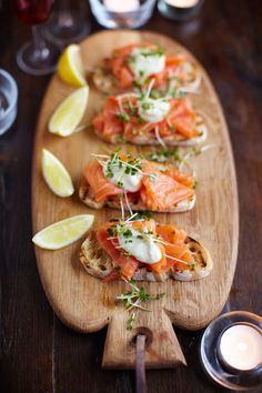 three pieces of bread with salmon on them and garnished with sour cream sauce