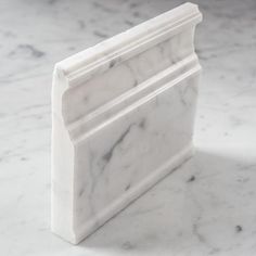 a close up of a marble bookend on a white table with grey speckles