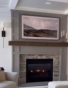 a living room filled with furniture and a fire place under a painting on the wall