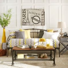 a living room filled with furniture and yellow flowers on top of a wooden coffee table