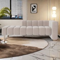 a white couch sitting on top of a rug in a living room