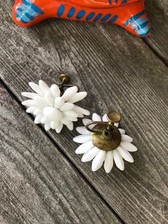 "Beautiful Vintage WESTERN GERMANY Celluloid White Daisy Flower Screw Back EARRINGS A beautiful vintage pair of earrings. With cool flexible petals . They measure approximately 1 1/2\" in diameter. They are in excellent vintage condition and will arrrive gifted nicely 🎀 Perfect for any ear- pierced or not. I don't have pierced ears and I cannot tell you how many gifts I have received of pierced earrings over the years ...vintage clips & screw backs are a pretty thoughtful solution if you ar Handmade Vintage White Clip-on Earrings, Retro White Flower Jewelry, Vintage White Flower Drop Earrings, Vintage White Drop Clip-on Earrings, Vintage Flower Shaped Clip-on Earrings, Vintage White Dangle Flower Earrings, Vintage Drop Earrings With Flower Charm, Vintage Flower Charm Dangle Earrings, Vintage Dangle Earrings With Flower Charm