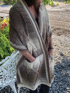 a woman is standing outside wearing a knitted cardigan