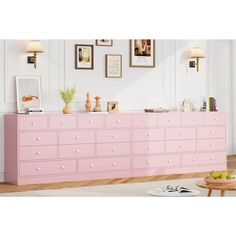 a pink dresser in a white room with pictures on the wall