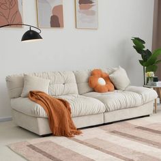 a living room with a couch, rug and two pictures on the wall above it