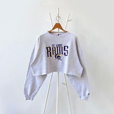 90 St. Louis Rams NFL cropped sweatshirt/ L * PLEASE READ BEFORE PURCHASE * PLEASE consider the PHOTOS before making the decision * The images may DIFFER in appearance from the actual product because we took pictures under daylight.  * PLEASE send your PHONE NUMBER after your purchase for the shipping company to contact you X No returns X No refund Condition : 9/10 More details : look at the pictures  Brand : Lee Size : L Pit to pit/ Chests : 27/54 inches  Length : 18 inches  Material : cotton p Fall Streetwear Cropped Sweater, Cropped Cotton Sweatshirt With Graphic Print, Graphic Print Cropped Cotton Sweatshirt, Fall Cropped Sweater For Streetwear, Cropped Sweater For Fall Streetwear, Trendy Cropped Sweatshirt With Letter Print, Cropped Tops With Ribbed Cuffs For Streetwear, Fall Streetwear Crop Top With Crew Neck, Casual Cropped Sweatshirt With Letter Print