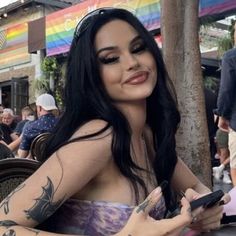 a woman with tattoos on her arm sitting at a table