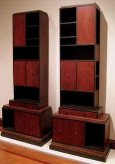 two wooden bookshelves sitting on top of a hard wood floor next to each other