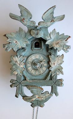 an old clock with two birds on it