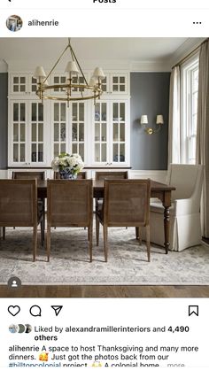 the dining room table is surrounded by white cabinets and gray walls, along with beige upholstered chairs