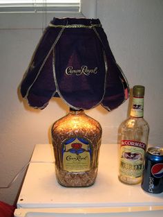 a lamp that is sitting on top of a white table next to bottles and cans