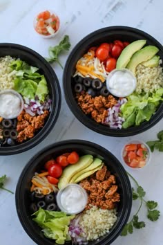 three black bowls filled with taco salad and toppings on top of a white table