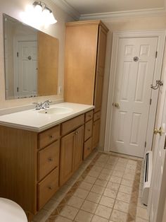 a bathroom with tile flooring and wooden cabinets