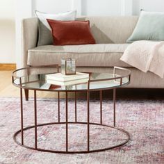 a living room with a couch, coffee table and rug on the floor in front of it