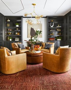 a living room filled with furniture and a chandelier hanging from the ceiling in front of bookshelves