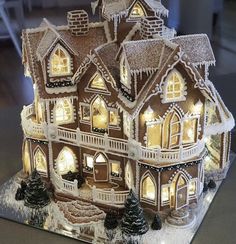 a lighted gingerbread house with snow on the roof