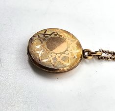 Gold filled etched locket mid century photo necklace. Good used condition with little to no signs of normal wear. Chain has early thumb clasp. Etched with the number 16 on the inside of each side of locket. Comes with vintage picture and frame. Necklace measures 15.5 inches long. Locket measures 5/8ths of an inch across. Antique Medallion Necklace With Locket, Vintage Medallion Locket Necklace As Gift, Antique Medallion Locket Necklace, Vintage Medallion Locket Jewelry, Vintage Brass Medallion Necklace With Locket, Vintage Medallion Necklace With Locket, Vintage Medallion Keepsake Jewelry, Vintage Filigree Medallion Locket Necklace, Antique Filigree Round Pendant Locket Necklace