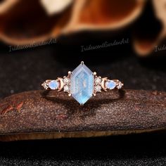 an image of a ring that is on top of a piece of wood with diamonds