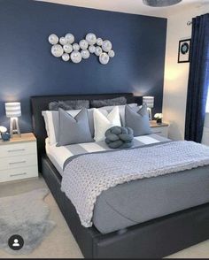 a bedroom with blue walls and white bedding, pillows and blankets on the bed