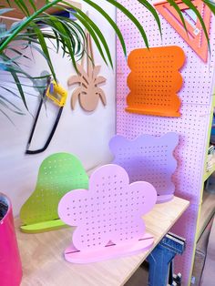 several paper hearts are on the shelf next to a potted plant