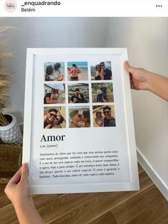 a person holding up a framed photo in front of a wall