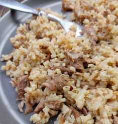 rice and meat on a plate with a spoon in the middle, ready to be eaten