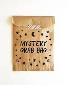 a brown bag with the words mystery grab bag written on it, hanging from a wall