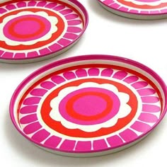 four pink and red plates sitting next to each other