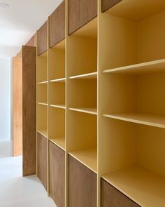 an empty room with yellow shelving and white flooring on the walls is pictured in this image