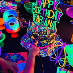 a birthday cake that is lit up with neon colors and the words happy birthday fabrana on it