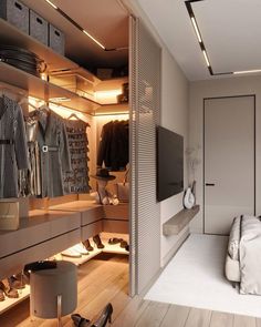 a walk in closet filled with lots of shoes and clothing on shelves next to a bed