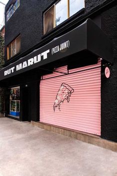 a pink and black building with graffiti on it