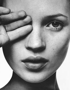 a black and white photo of a woman's face with her hand on the forehead