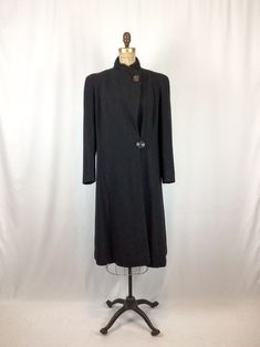 "Vintage 1940s black wool boucle swing coat Stand collar lined in black curly lamb and if top button not closed it turns into a shawl collar Down front both sides is a column of embossed wave design Soft shoulders with light shoulder pads Long sleeves Two large round black buttons for closure Fully lined in black silk MEASUREMENTS : Fits like a medium Shoulders: 15.5\" Bust: 42\" Waist: 40\" Hips: 44\" Armhole: 10\" diameter Sleeve length 23.5\" Sleeve opening: 6\" diameter Length: 42\" Brand/La Portland Fashion, Vintage Wife, Coat Stand, Black Curly, Vintage 40s, Coat Vintage, Coat Stands, Wave Design, Shawl Collar