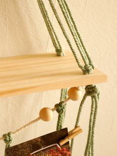 a piece of wood hanging from a rope with some string attached to it and balls on the strings