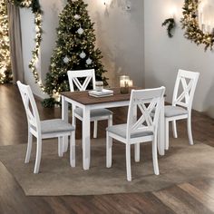 a dining room table with white chairs and christmas trees in the background on a wooden floor