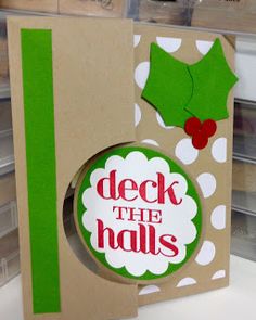 a close up of a christmas card with the word deck the hall on it and holly decorations