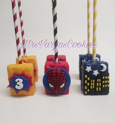 three birthday candles decorated to look like superheros and spider - man characters with numbers on them