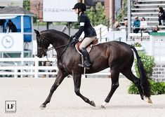 a woman riding on the back of a brown horse