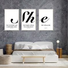 two black and white posters on the wall above a bed in a room with grey walls