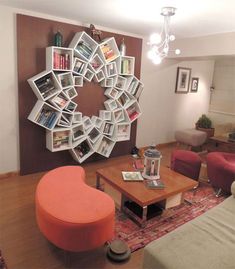 a living room filled with furniture and a circular book shelf on the wall above it