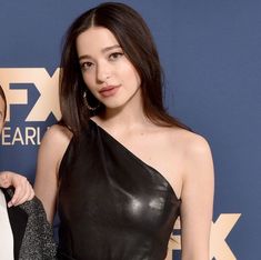 two women standing next to each other on a red carpet