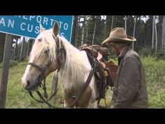 a man standing next to a white horse near a sign that says san cristoto