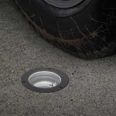 a small hole in the ground next to a tire