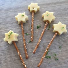 five crackers with cheese and sprinkles arranged in the shape of stars