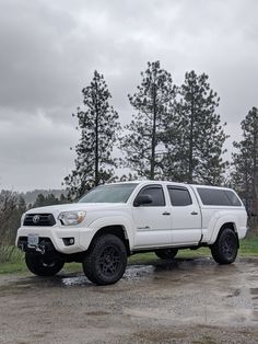 a white truck parked on top of a dirt field