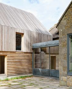 an exterior view of a building with wooden slats on the side and windows in the front